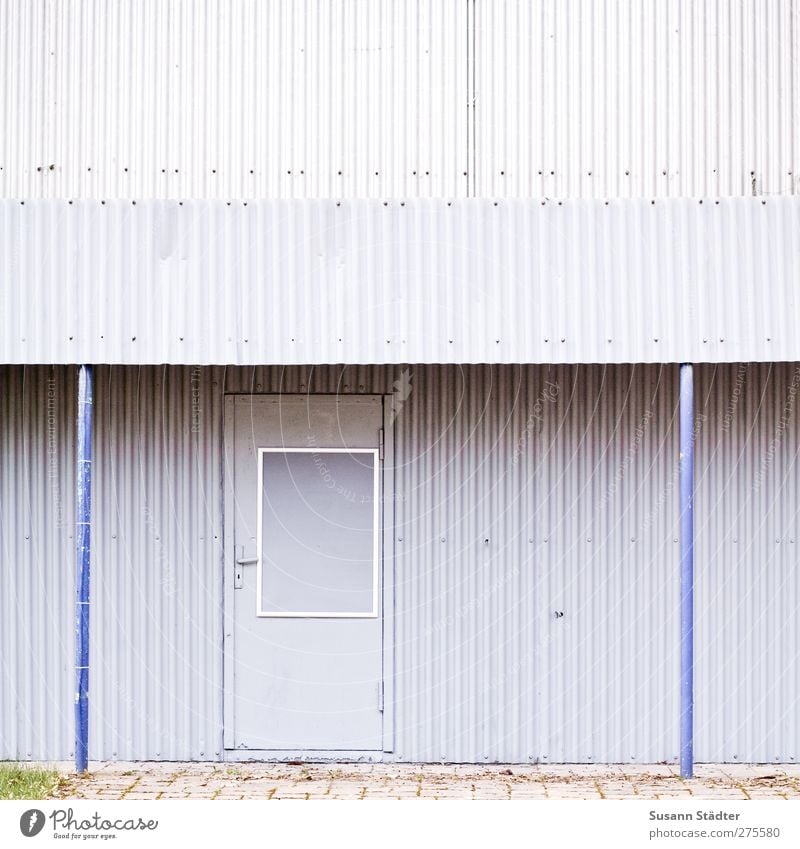 I-I Haus Hütte Parkhaus Bauwerk Gebäude Architektur Fassade kalt retro trashig blau grau Wellblech Wellblechhütte Wellblechwand Tür Eingang Pflastersteine
