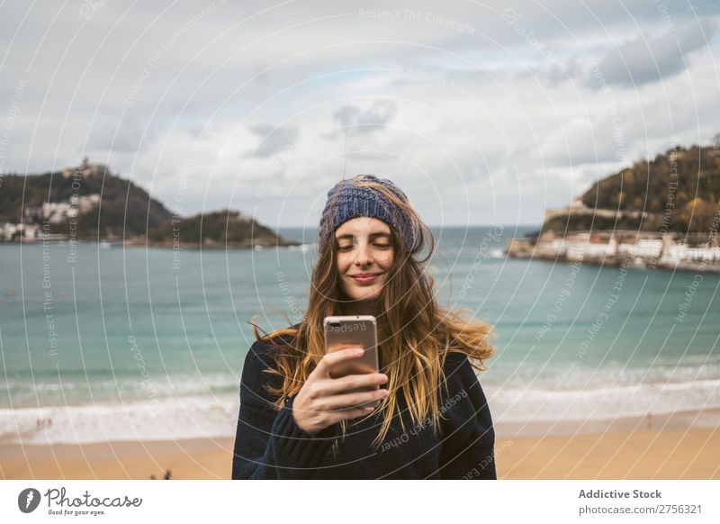 Frau mit Smartphone am Meer Jugendliche Küste hübsch PDA benutzend Browsen Surfen attraktiv Hut Natur Wasser Ferien & Urlaub & Reisen Strand San Sebastián