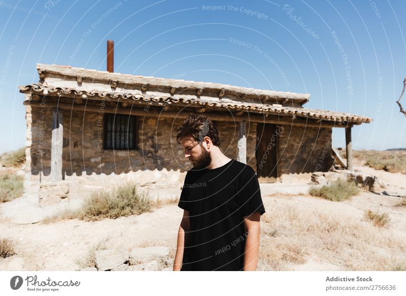 Mann, der in der Nähe eines verlassenen Hauses in der Wüste posiert. Ferien & Urlaub & Reisen Lifestyle Mensch Erwachsene Natur Abenteuer Ausflug Tourist