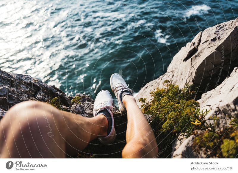 Mann sitzt auf einer Klippe. Wüste Ferien & Urlaub & Reisen Beine Lifestyle Mensch Erwachsene Stein Felsen Natur Abenteuer Freiheit Reisender Ausflug Tourist
