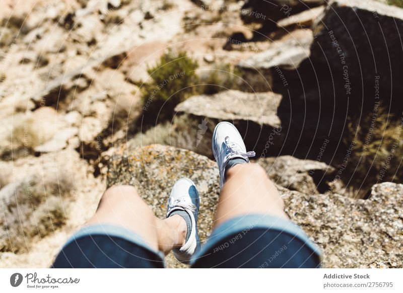 Mann sitzt auf einer Klippe. überhängend Wüste Ferien & Urlaub & Reisen Beine Lifestyle Mensch Erwachsene Stein Felsen Natur Abenteuer Freiheit Reisender