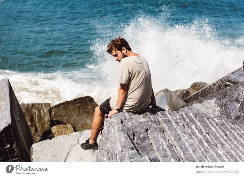 Mann auf Steinen auf dem Meer sitzend Wellen Geplätscher Gezeiten Wasser Mensch Natur Jugendliche Einsamkeit Ferien & Urlaub & Reisen Küste Freizeit & Hobby