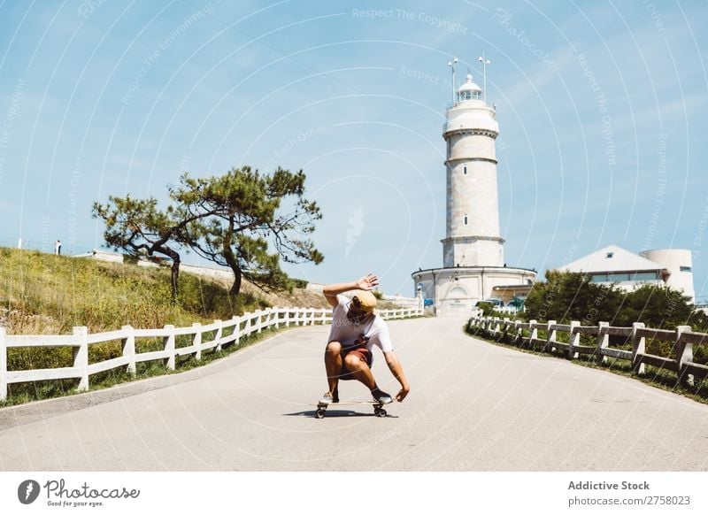 Mann Skateboarding am Leuchtfeuer Skateboarderin Reiten Asphalt Leuchtturm Seeküste Sport Lifestyle Schlittschuhlaufen Schlittschuhe extrem Sonnenstrahlen