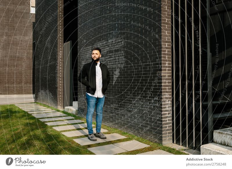 Modischer junger Mann auf der Straße Wegsehen nachdenklich besinnlich stylisch Baustein Wand Stehen selbstbewusst cool Person Porträt modern Model modisch