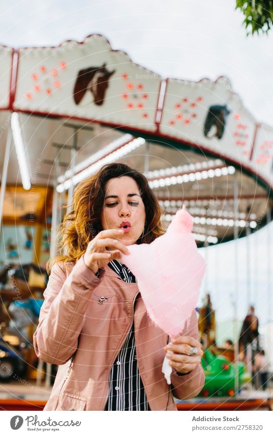 Frau mit Zuckerwatte im Park Kinderkarussell Person rosa hübsch süß Lebensmittel essen Spaß Lifestyle Porträt jung Lächeln Beteiligung Snack außerhalb weich