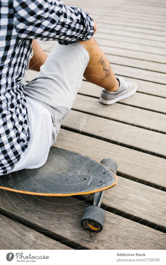 Tätowierter Mann auf Skateboard sitzend Skateboarderin Schlittschuhe Stadt Sport Skateboarding Jugendliche Holzplatte Schlittschuhlaufen Mensch Lifestyle Typ