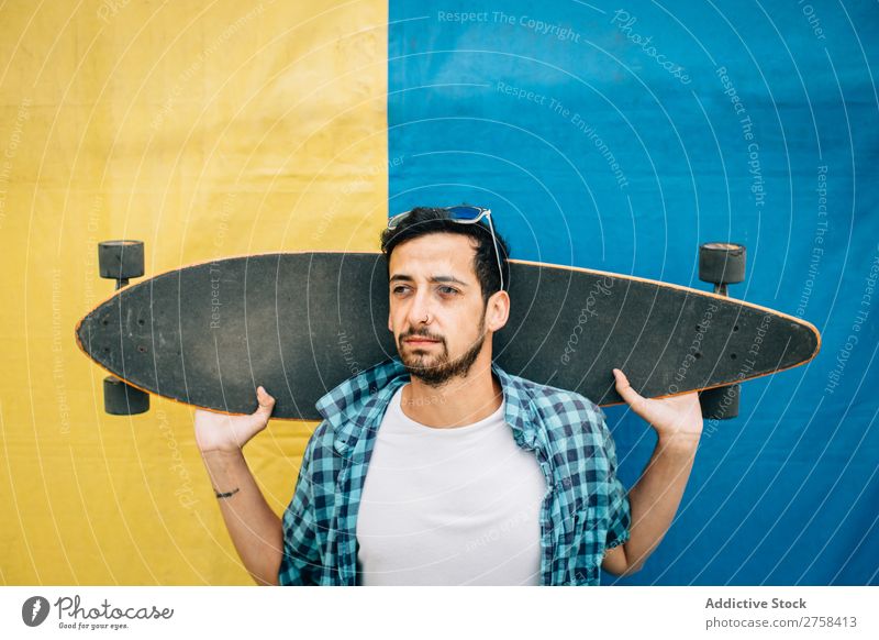 Bartiger Mann hält Skateboard. Jugendliche Hintergrundbild Sport Skateboarderin Skateboarding Schlittschuhe Lifestyle Stadt Holzplatte modern Sommer extrem