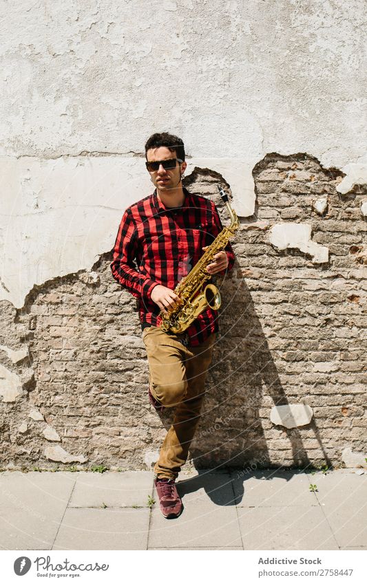 Cooler Musiker mit Saxophon Mann Sonnenbrille selbstbewußt Coolness Wand Jugendliche Jazz Instrument Musical Leistung Saxophonspieler Mensch Spieler Artist