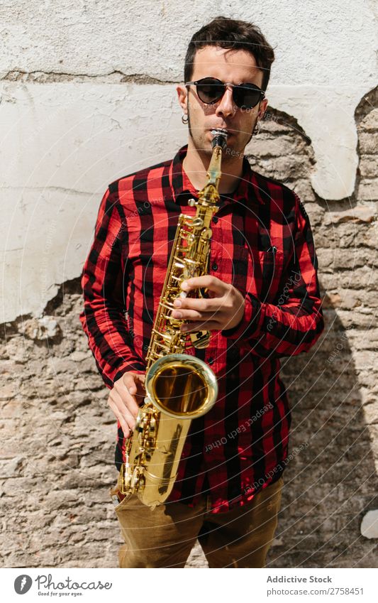 Cooler Musiker mit Saxophon Mann Sonnenbrille selbstbewußt Coolness Wand Jugendliche Jazz Instrument Musical Leistung Saxophonspieler Mensch Spieler Artist