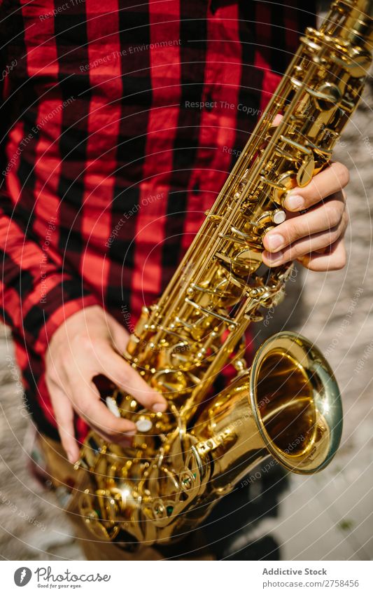 Lächelnder Jazzmann mit Saxophon Musiker Mann Sonnenbrille selbstbewußt Coolness heiter Wand Jugendliche Instrument Musical Leistung Saxophonspieler Mensch