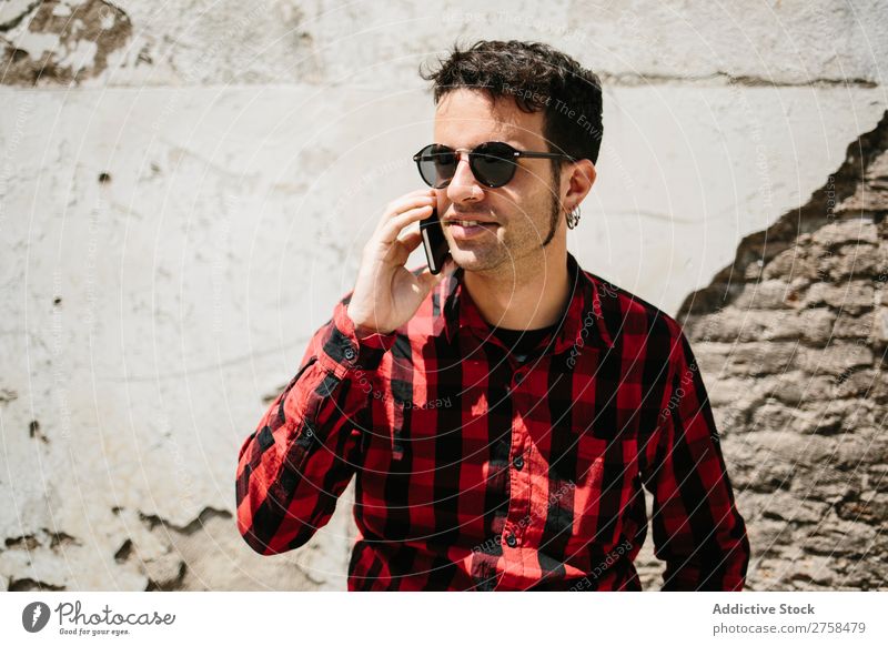 Stilvolles Männergespräch Telefon Mann PDA sprechen Wand Sonnenstrahlen Mobile gutaussehend Coolness Porträt Lifestyle Mitteilung lässig Jugendliche