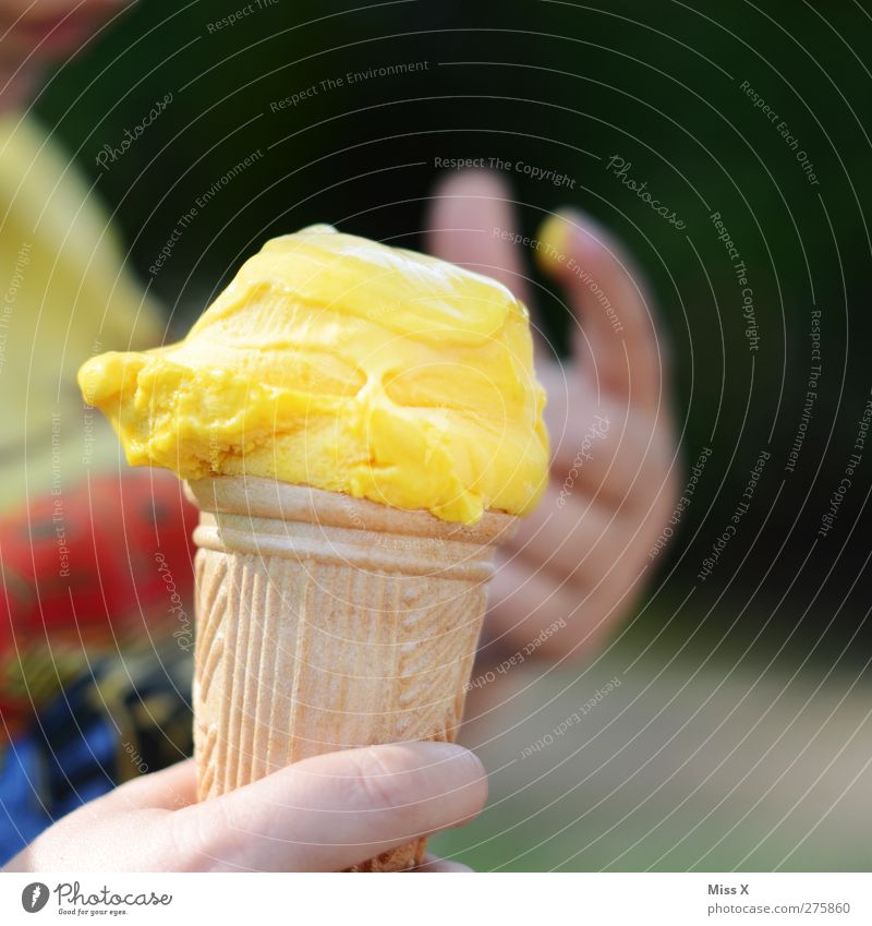 Eis Lebensmittel Speiseeis Ernährung Essen Kind Hand Finger kalt lecker gelb Eiswaffel Vanilleeis lutschen Sommer Farbfoto mehrfarbig Außenaufnahme Nahaufnahme