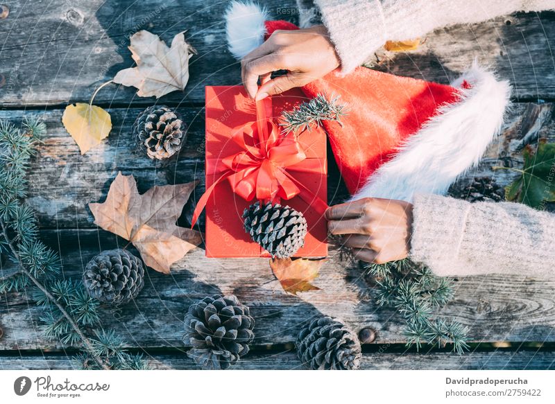 Frau Arme machen Weihnachtsdekoration in einem Holztisch im Freien Weihnachten & Advent Geschenk Hut Weihnachtsmann Leben Stillleben Hand Hintergrundbild