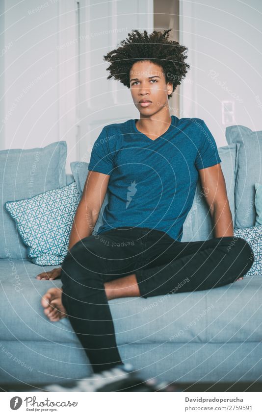 Porträt eines jungen nachdenklichen gemischtrassigen Mannes, der auf dem Sofa sitzt. schwarz Jugendliche Mensch Rennsport Amerikaner Afrikanisch