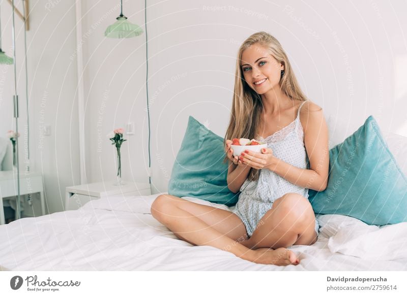 Junge, gesunde, schöne, blonde Frau im Bett, die Früchte isst. Schlafzimmer Porträt Frucht Lebensmittel Fressen Lächeln Jugendliche Mädchen Gesundheit Fürsorge