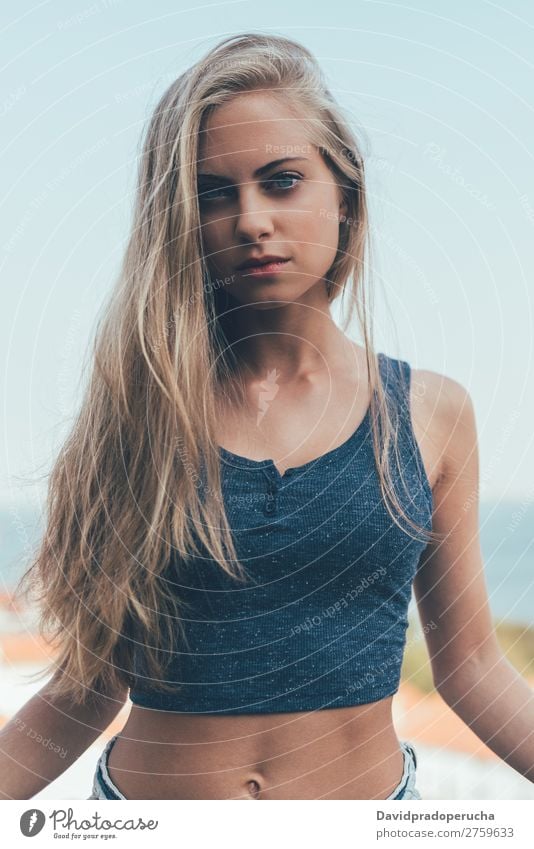Porträt einer jungen, hübschen, gesunden, blonden Frau, die sich posiert. Lächeln Jugendliche Fürsorge sportlich sitzen blau Auge Gesundheit Erotik bauchfrei
