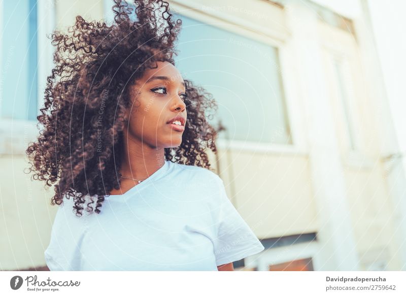 Junge, schöne, schwarze Frau auf der Treppe, die posiert. Porträt Lächeln Person gemischter Abstammung Damenschuhe Rennsport amerika Afro-Look lockig Behaarung