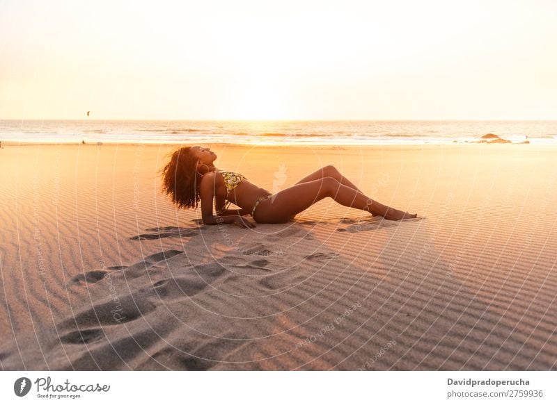Wunderschöne junge Frau, die auf dem Sand am Strand posiert. Pose vereinzelt romantisch Meer Sonne Ferien & Urlaub & Reisen Natur Schwimmsport Anzug Freude gold