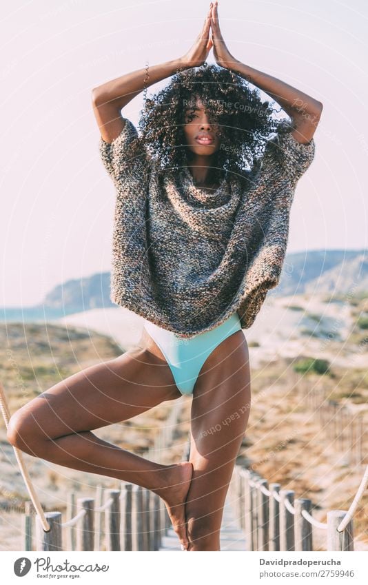 Junge schwarze Frau beim Yoga in einer hölzernen Fußgängerbrücke am Strand Hintergrundbild Bikini üben Brücke Küste krause Haare Ausflugsziel Behaarung