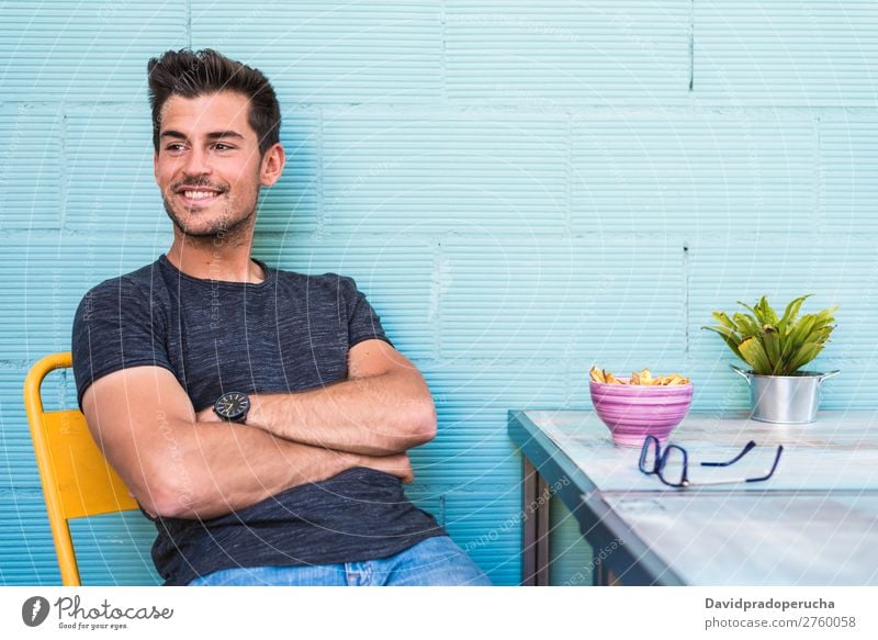 Glücklicher junger Mann, der in einem Restaurant sitzt. Erwachsene Einsamkeit attraktiv schön blau hell Kaukasier Kaffee Café mehrfarbig genießend Lebensmittel