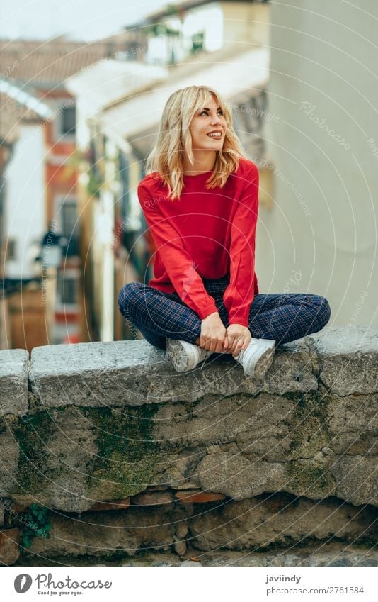 Glückliche junge blonde Frau sitzt auf städtischem Hintergrund. Lifestyle Stil schön Haare & Frisuren Mensch feminin Junge Frau Jugendliche Erwachsene 1