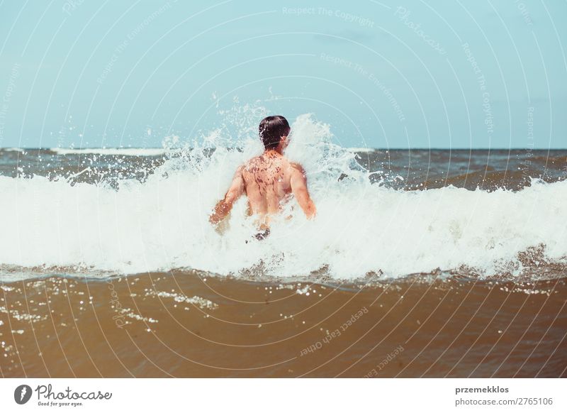 Junger Mann, der die hohen Wellen im Meer genießt. Lifestyle Freude Glück Erholung Freizeit & Hobby Spielen Ferien & Urlaub & Reisen Sommer Strand Mensch
