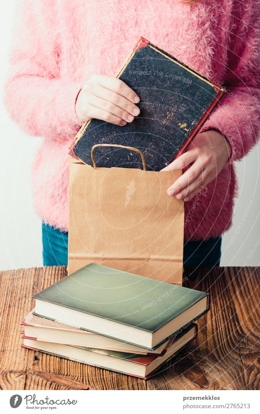 Junges Mädchen, das die Bücher in eine Papiertasche im Buchladen legt. Lifestyle Erholung Freizeit & Hobby lesen Schule lernen Mensch Frau Erwachsene