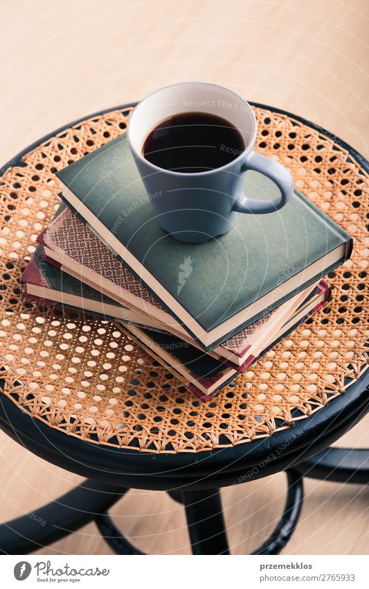 Ein paar Bücher mit einer Tasse Kaffee auf dem Stuhl Becher Lifestyle Erholung Freizeit & Hobby lesen Tisch Buch genießen braun Geborgenheit bequem gemütlich