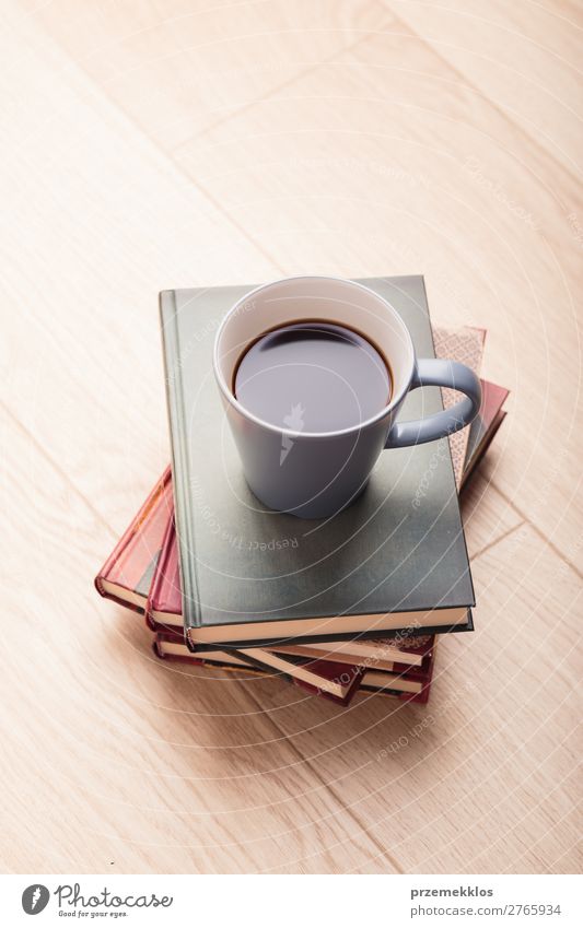 Ein paar Bücher mit einer Tasse Kaffee auf Holzboden Lifestyle Erholung Freizeit & Hobby lesen Tisch Buch genießen braun Geborgenheit bequem gemütlich trinken