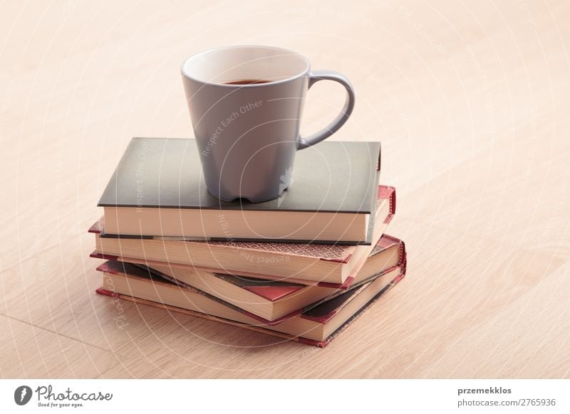 Ein paar Bücher mit einer Tasse Kaffee auf Holzboden Becher Lifestyle Erholung Freizeit & Hobby lesen Tisch Buch genießen braun Geborgenheit bequem gemütlich