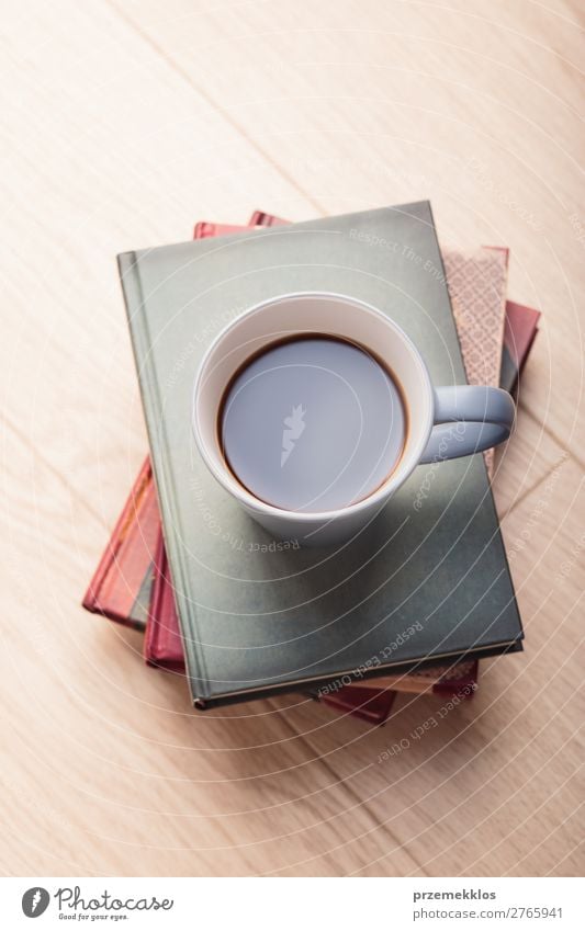 Ein paar Bücher mit einer Tasse Kaffee auf Holzboden Becher Lifestyle Erholung Freizeit & Hobby lesen Stuhl Tisch Buch genießen Geborgenheit bequem gemütlich