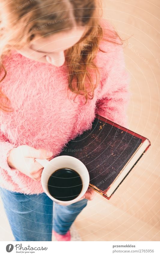 Mädchen mit Buch und Tasse Kaffee zum Entspannen mit einem Buch Lifestyle Erholung Freizeit & Hobby lesen Kind Mensch Frau Erwachsene Wärme blond genießen rosa