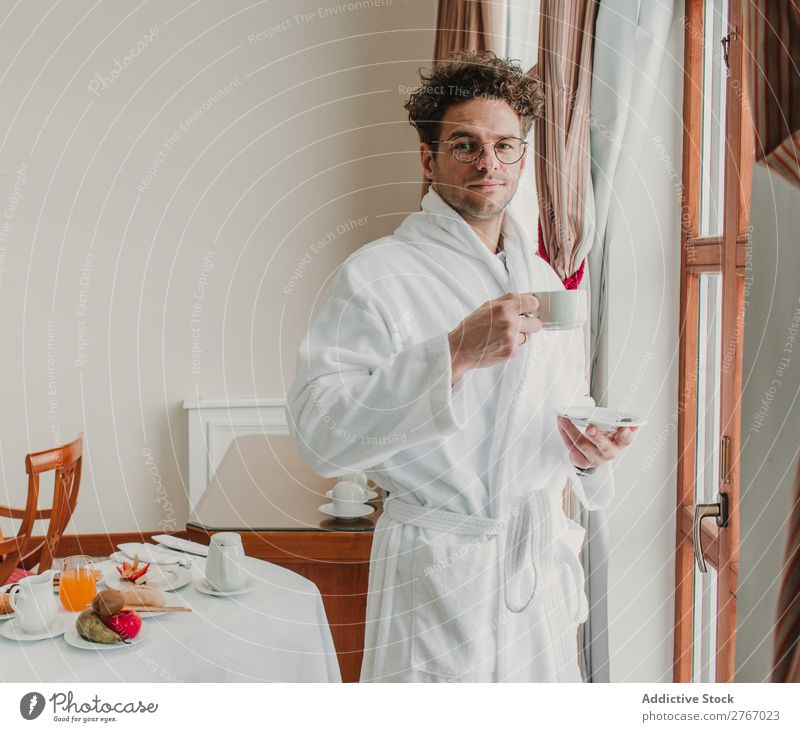 Mann im Bademantel mit Tasse selbstbewußt Stil Keramik Fenster trinken Frühstück Zimmerservice Hotel Raum Schlafzimmer heimwärts Innenarchitektur Möbel Wohnung