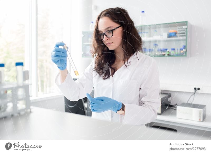 Frau, die auf das Reagenzglas schaut. Labor Arbeit & Erwerbstätigkeit Wissenschaften Reaktionen u. Effekte beobachten Mensch forschen Wissenschaftler Medikament