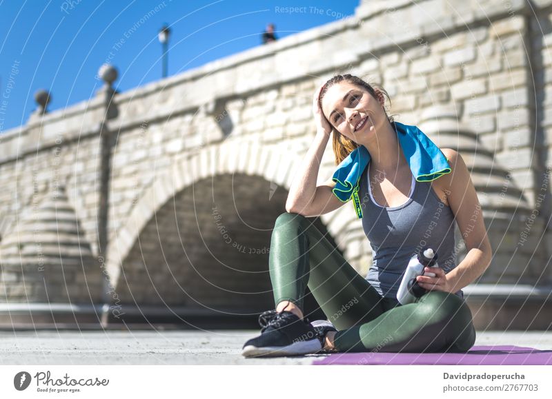 Frau ruht sich aus und trinkt Wasser mit Handtuch nach dem Training. Lifestyle schön Körper Erholung Meditation Sport Yoga Mensch Erwachsene Natur Wärme Park