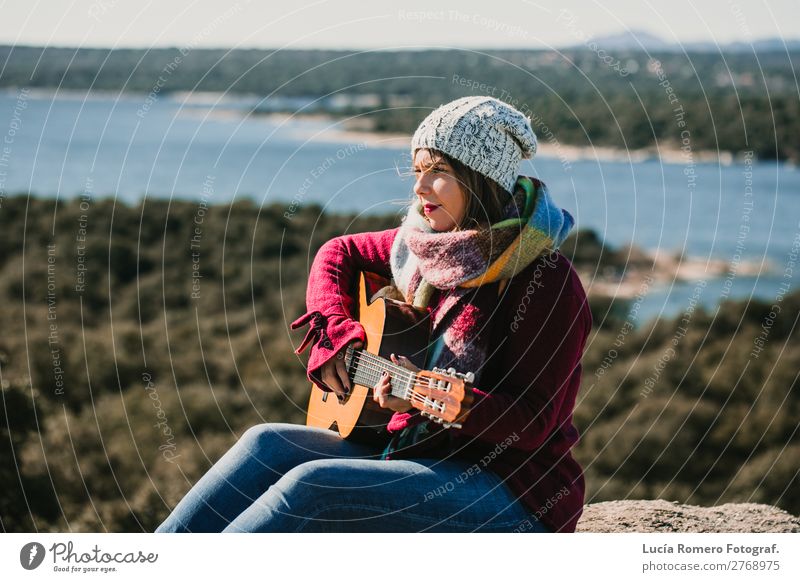 Frau, die im Freien Gitarre spielt. Lebensstil Lifestyle Freude Glück Erholung Freizeit & Hobby Spielen Ferien & Urlaub & Reisen Winter Musik Mensch feminin