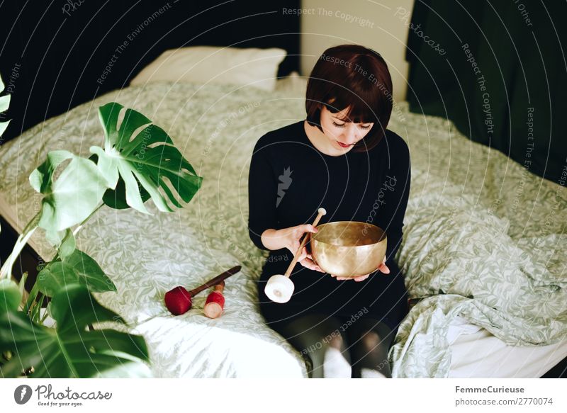 Mindfulness - Woman with singing bowl in her cozy home Lifestyle feminin Frau Erwachsene 1 Mensch 18-30 Jahre Jugendliche 30-45 Jahre Zufriedenheit Erholung