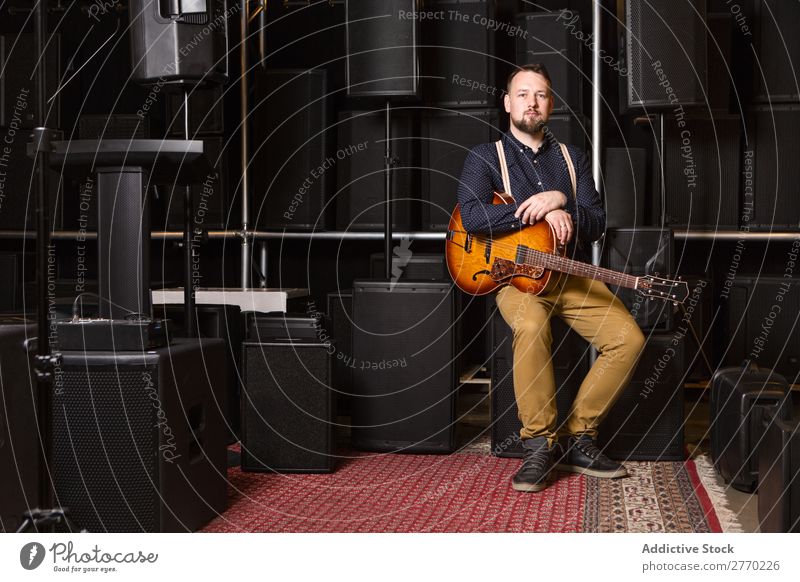 Gitarrist auf Gitarrencombo sitzend Mann kaufen Blick in die Kamera Gitarrenkombination Verkäufer Kunde Reihen Musical akustisch Gerät Mensch Business Porträt