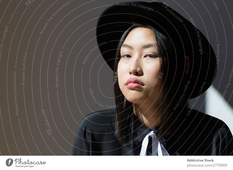 Stylische asiatische Frau mit Blick auf die Kamera Stil modisch Hut Kleid schön Mode Beautyfotografie Jugendliche Model Porträt attraktiv elegant Glamour hübsch
