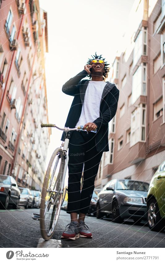 Gutaussehender junger Mann mit Handy und festem Fahrrad. Jugendliche Afrikanisch schwarz Mulatte Afro-Look Mobile Fixie Telefon Lifestyle stehen Fahrradfahren