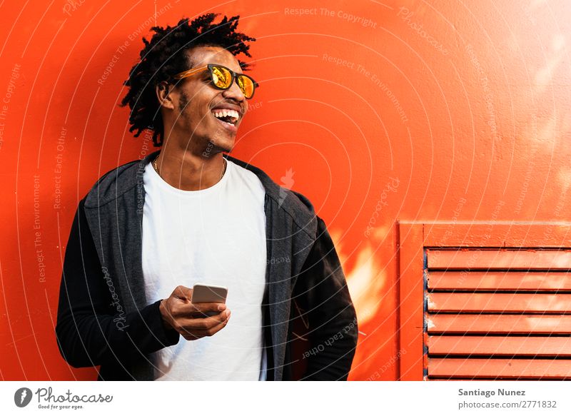 Afrojunger Mann benutzt Handy. Jugendliche Afrikanisch schwarz Mulatte Afro-Look Mobile Telefon Lifestyle stehen Fahrradfahren benutzend Solarzelle