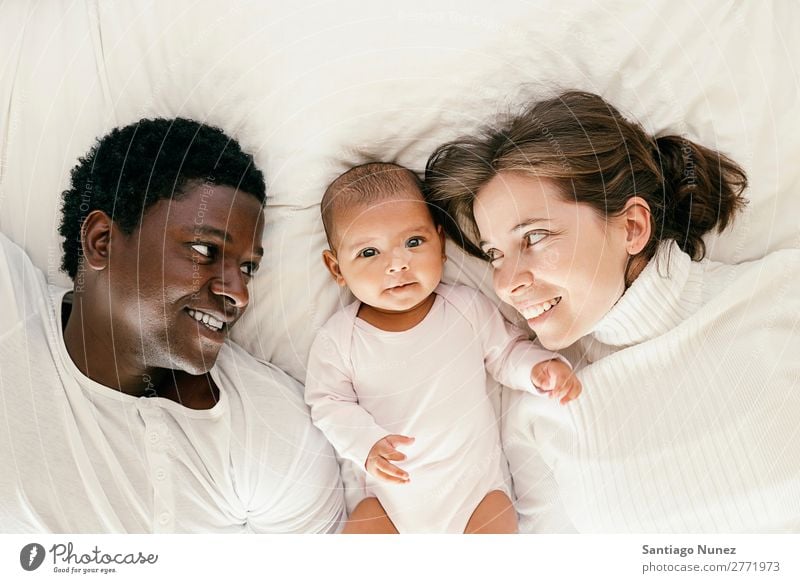 Glückliche Familie, Mutter, Vater und Baby. Junge Kind Bett Mädchen lügen neugeboren Eltern Familie & Verwandtschaft multiethnisch Liebe Afrikanisch vielfältig