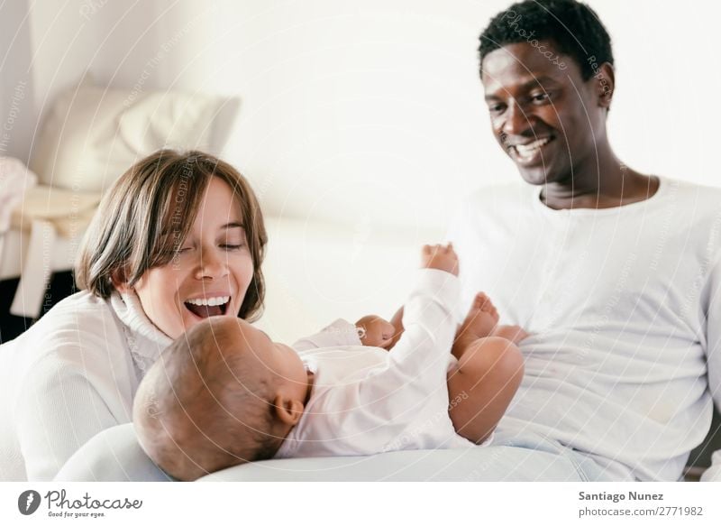 Glückliche Familie, Mutter, Vater und Baby. Junge Kind Bett Mädchen lügen neugeboren Familie & Verwandtschaft Eltern multiethnisch Afrikanisch vielfältig Mensch