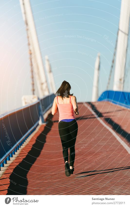Junge Fitness-Läuferin, die auf der Stadtbrücke läuft. rennen Aktion Athlet sportlich Eisenbahn Frau Training üben Sport stark Körper anstrengen Lichtschein