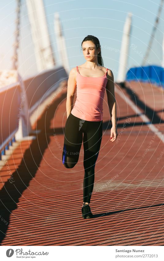 Junge Fitnesstrainerin Läuferin, die die Beine nach dem Lauf streckt. rennen Aktion Athlet sportlich Eisenbahn Frau Training üben Sport Dehnung strecken Handy