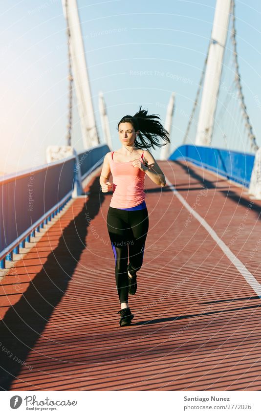 Junge Fitness-Läuferin, die auf der Stadtbrücke läuft. rennen Aktion Athlet sportlich Eisenbahn Frau Training üben Sport stark Körper anstrengen Lichtschein