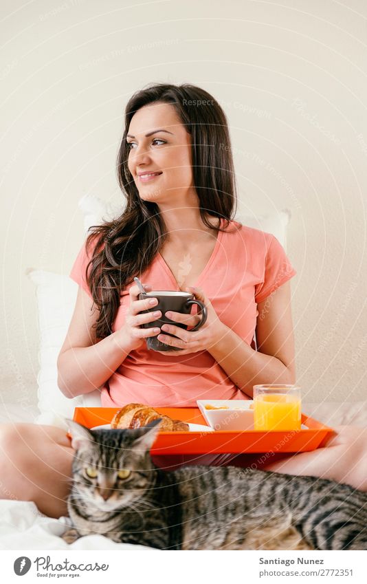 Glückliche Frau beim Frühstück in ihrem Schlafzimmer. Bett Kaffee Frucht Saft Orangensaft Croissant Ernährung Arbeit & Erwerbstätigkeit Technik & Technologie