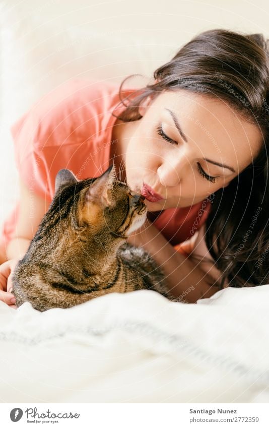 Glückliche Frau, die ihre Katze küsst. Mädchen Umarmen Tier Haustier Küssen Katzenbaby niedlich schön Mensch Liebe heimwärts Gesicht Mode weiß Behaarung