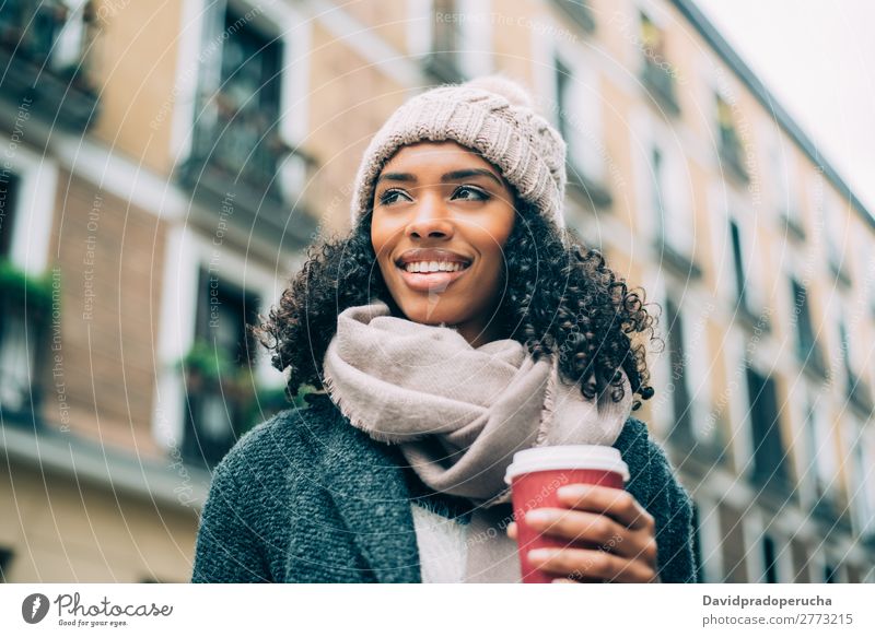 Junge schwarze Frau, die Kaffee trinkt, wandert im Winter durch die Straßen von Madrid. Ferien & Urlaub & Reisen wandern Großstadt Stadt Zentrum Spanien