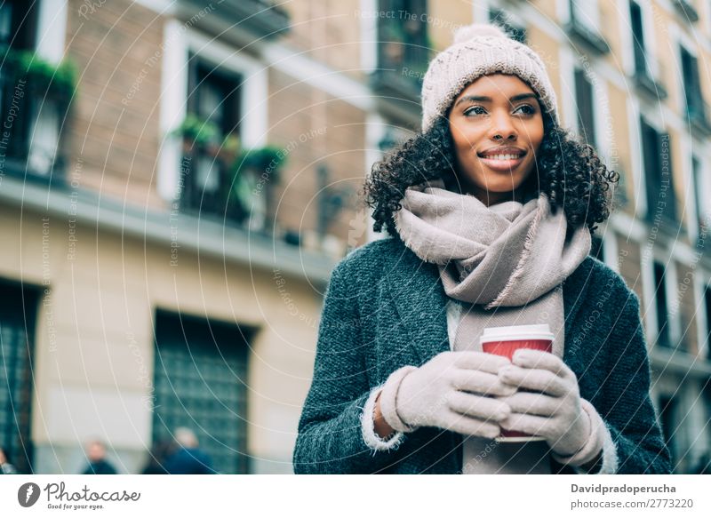 Junge schwarze Frau, die Kaffee trinkt, wandert im Winter durch die Straßen von Madrid. Ferien & Urlaub & Reisen wandern Großstadt Stadt Zentrum Spanien